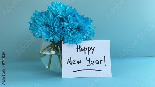Happy new year - with blue flowers and lettering on light blue background 