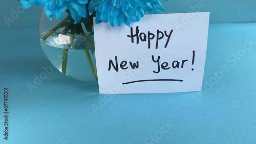 Happy new year - with blue flowers and lettering on light blue background 