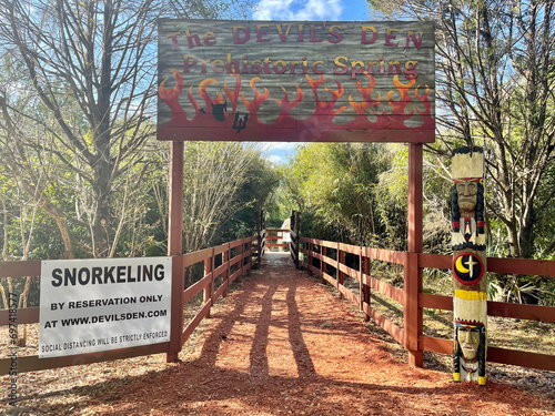 Photos Welcome sign with devil and pitchfork at entrance to the sinkhole at Devil's Den