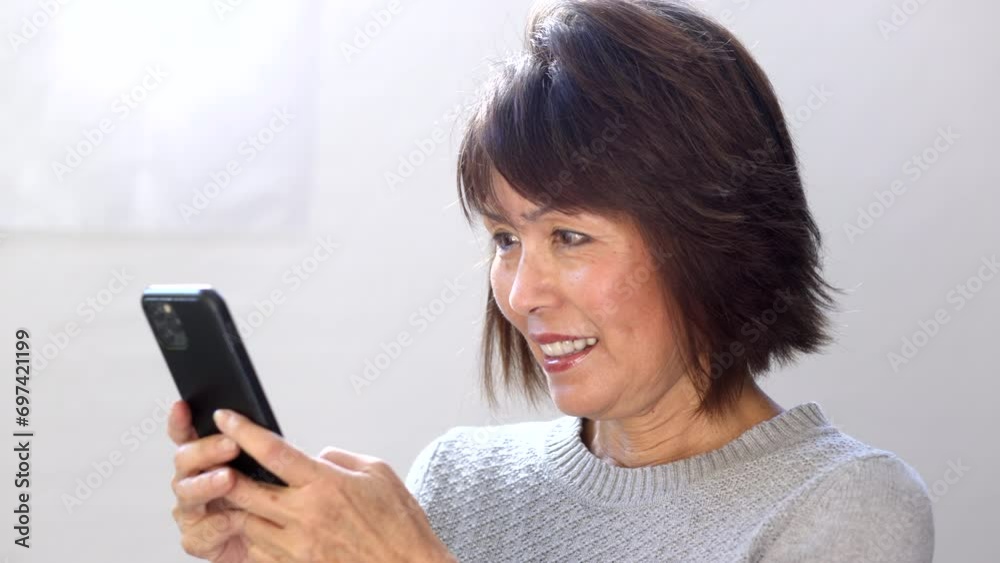 Cheerful stylish attractive woman smiling texting email messages holding mobile cell phone standing head shot Cheerful stylish attractive woman smiling texting email messages holding mobile cell phone standing head shot