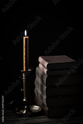 Candle illuminates old books