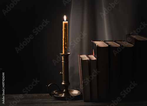 Candle illuminates old books