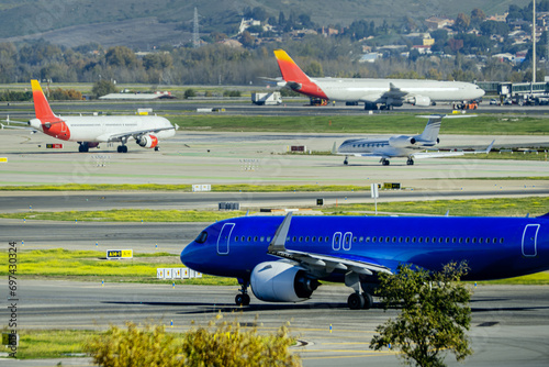 Departure air traffic with a blue plane at Madrid Barajas airport photo
