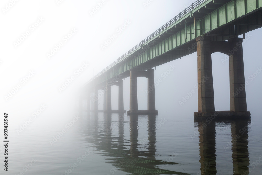 A bridge vanishes into fog and mist. Located at Captree State Park, Long Island New York. The bridge leads to Robet Moses State Park on Fire Island