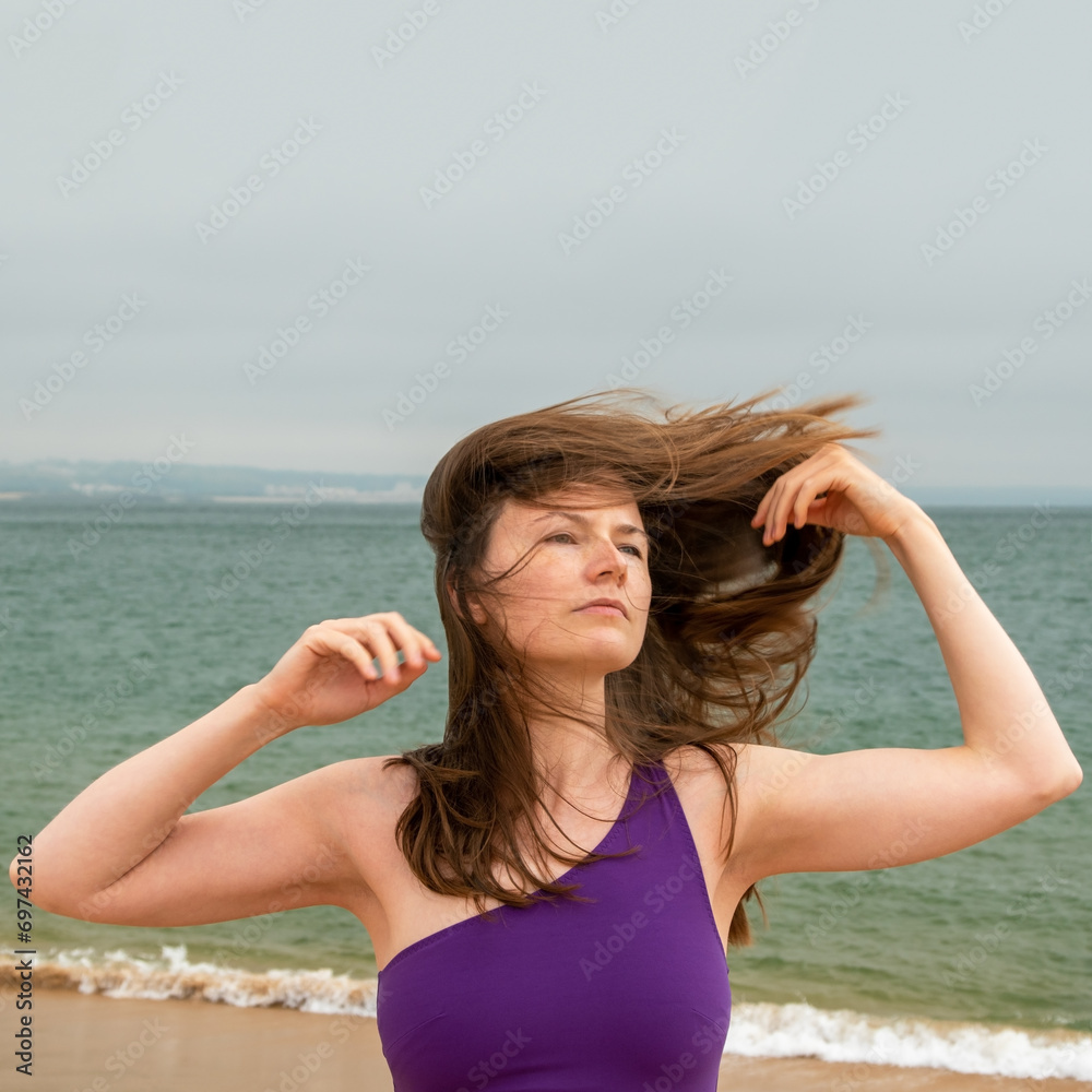 Beautiful young woman on the beach with wind in her hair. Beautiful young woman on the beach with wind in her hair.