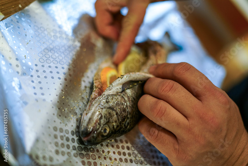 Preparing trouts with lemons, butter and fresh dill. 