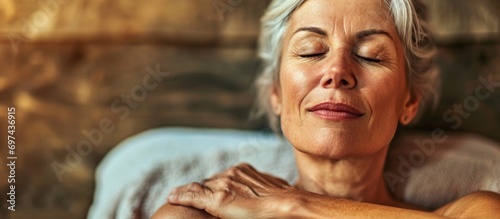 An African woman relaxing at a spa, receiving massage and skin hydration. photo