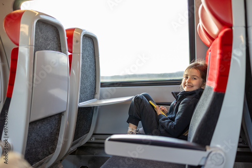 Cute little girl talking by telephone  in train 