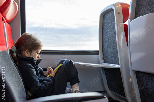 Cute little girl playing with telephone  in train 