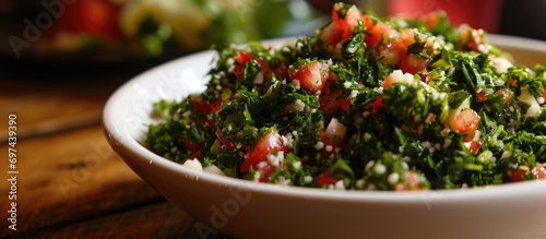 Tabbouleh served in a white bowl, a Lebanese salad. photo