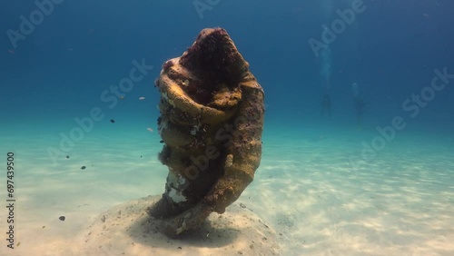 paisaje subacuatico de aguas cristalinas del mar caribe y una estatua con forma de concha y silueta de virgen sumergida en el mar. photo