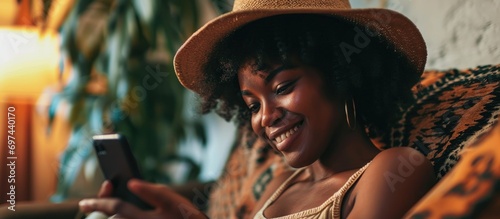 Content black woman at home reading a text message with a smile.