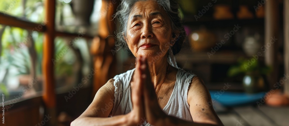 An older Asian lady practices yoga at home. An older Asian lady practices yoga at home.