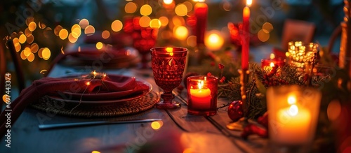 Setting for a romantic dinner or holiday table  adorned with red decor and candlelight.