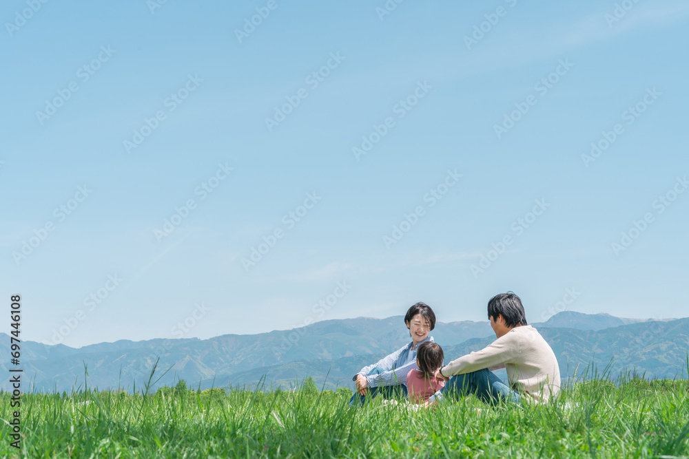 公園でピクニックする日本人家族（コピースペース）
