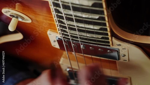 Male guitarist performing solo on electric guitar using pick. Vertical video photo