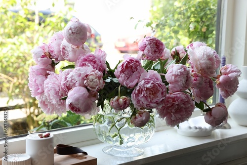 Fototapeta Naklejka Na Ścianę i Meble -  Beautiful pink peonies in vase on window sill. Interior design