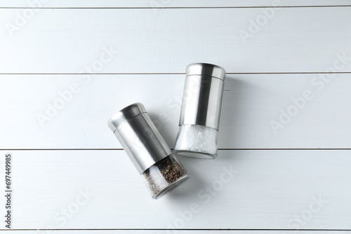 Salt and pepper shakers on white wooden table, flat lay photo