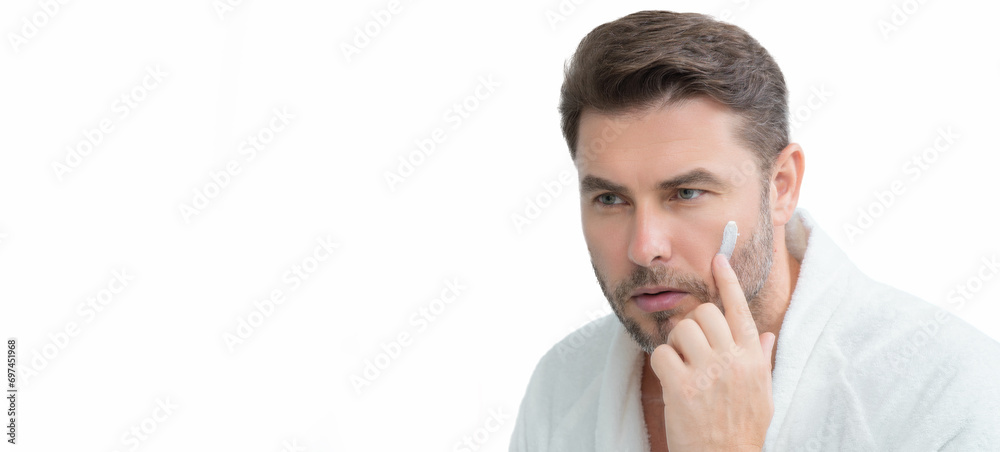 Close up portrait of man 40s applying cream on face. White isolated banner with copy space. Portrait of beauty man with cosmetic cream on skin. Facial treatment. male beauty. Close up portrait of man 40s applying cream on face. White isolated banner with copy space. Portrait of beauty man with cosmetic cream on skin. Facial treatment. male beauty.