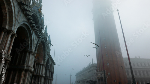 Venice in winter fog. Piazza San Marco, St Mark's Basilica and Campanile with birds.
