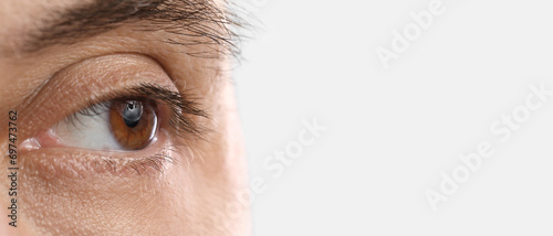 Man with brown eyes on light background, closeup. Banner for design