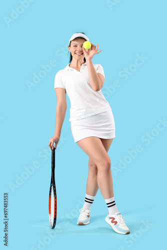 Female tennis player with racket and ball on blue background © Pixel-Shot