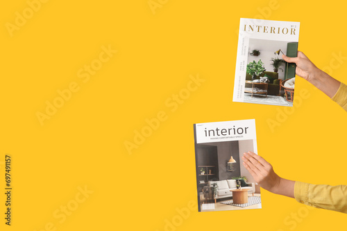 Young woman with interior magazines on yellow background photo