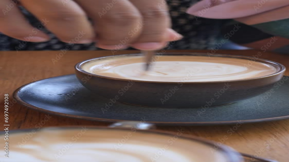 person hand stirring coffee with spoon. person hand stirring coffee with spoon.