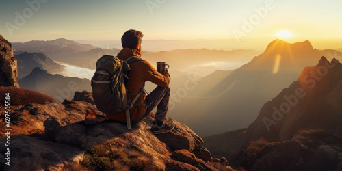Young man drinking coffee on the top of mountain.