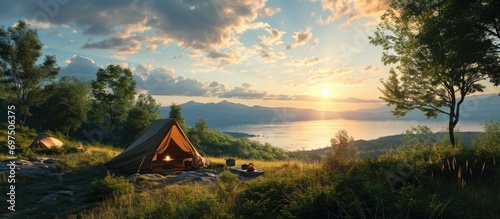 A hilltop campsite shows a peaceful lake view while they cook dinner and get ready. photo