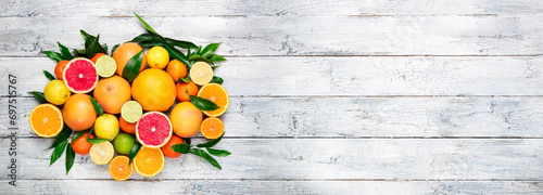 Fresh citrus fruits background. Orange, grapefruit, lemon, lime, tangerine. Mix citrus fruits with leaves. Long web format for banner. Top view