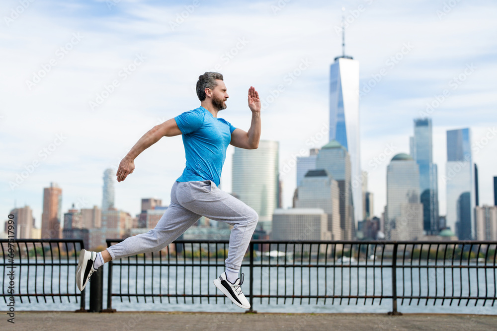 Mature man doing sport on street. Runners sprinting outdoors. Sport man training in a urban area, healthy lifestyle sport concept. Man in sportswear jogging exercise at public park in New York City.