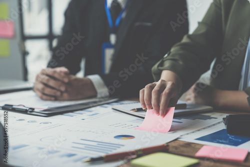 Businessmen meet to consult, brainstorm ideas, record on notepads. Brainstorming of colleagues in the office, project analysis report Check investment results and profits of the company.