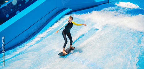 Foto Beautiful young woman surfing on a wave simulator at a water amusement park
