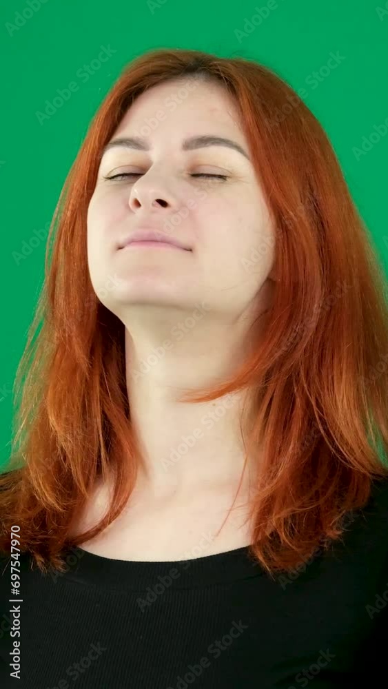 calm yourself slowly exhale and inhale hold your breath close your eyes face of a young red-haired woman on a green background taking a deep breath relaxation relaxation find calm in yourself calm yourself slowly exhale and inhale hold your breath close your eyes face of a young red-haired woman on a green background taking a deep breath relaxation relaxation find calm in yourself