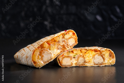 French tacos with chicken popcorn. Served with french fries on a black background