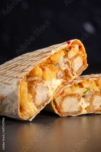 French tacos with chicken popcorn. Served with french fries on a black background