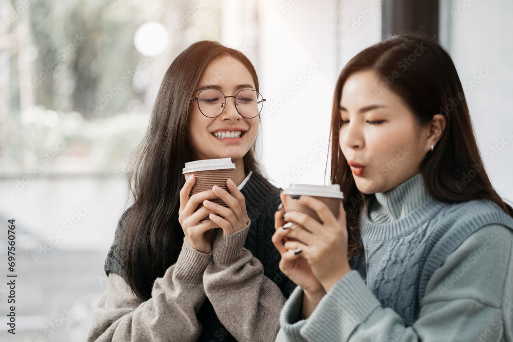 female colleague of half Asian descent holds a cup of coffee and smiles happily.