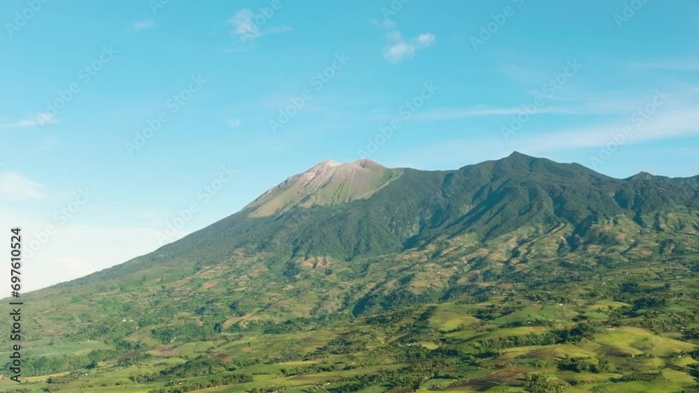 Aerial view of farmland with plantings against a background of mountains and blue sky. Kanlaon volcano. Negros, Philippines Aerial view of farmland with plantings against a background of mountains and blue sky. Kanlaon volcano. Negros, Philippines