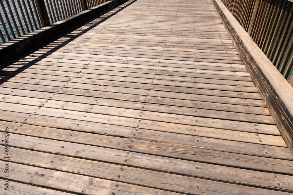 Texture wooden bridge over the ocean. Wooden access bridge to the islet of La Fermina. Lanzarote, Canary Islands, Spain. Texture wooden bridge over the ocean. Wooden access bridge to the islet of La Fermina. Lanzarote, Canary Islands, Spain.