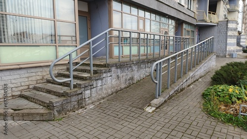 A sloping tile ramp with metal railings was made for people with disabilities in wheelchairs to enter the administrative building. Thus, a barrier-free environment was created. There is a staircase