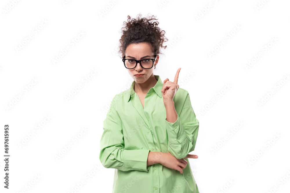 young caucasian woman with black curly hair wearing glasses and light green shirt on a white background with copy space young caucasian woman with black curly hair wearing glasses and light green shirt on a white background with copy space