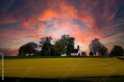 Kleine Kapelle zwischen Bäumen mit rotem Himmel