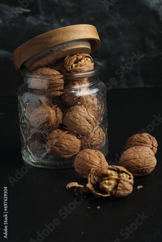 Walnuts in a glass jar on a black background