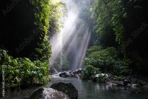 Sun beams in a creek leading to Hidden waterfall Sekumpul. Bali  Indonesia.