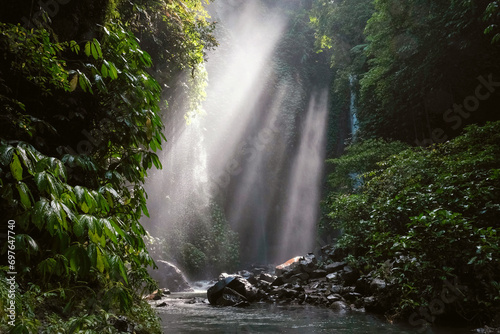 Fototapeta Naklejka Na Ścianę i Meble -  View of a creek leading to Hidden waterfall Sekumpul and sun beams. Bali, Indonesia.