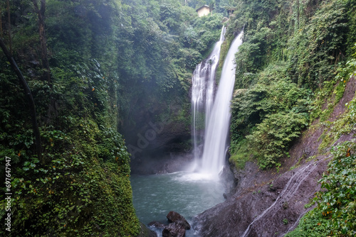 Long exposure shot of Aling-Aling waterfall on cloudy day. Bali  Indonesia.