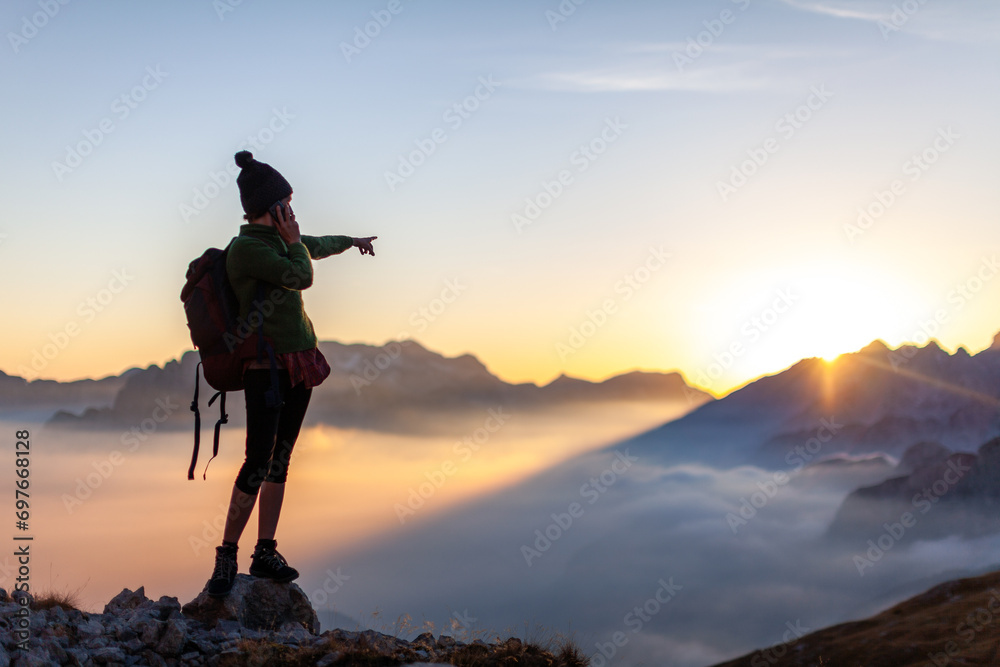 Woman Hiker Asking for Direction Navigation Tips trough her Smart Phone from High Mountains of European Alps Summit Remote Location - Mobile Communications Achievements Concept
