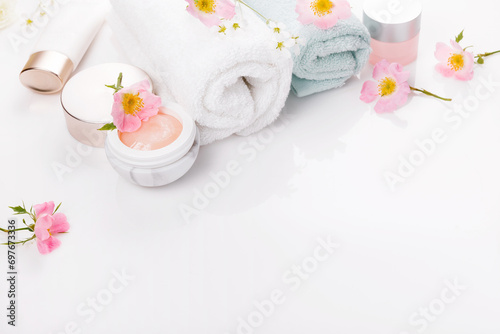 Beauty and spa concept. Towel and skin care cosmetics with rose hips on a white background. Flat lay
