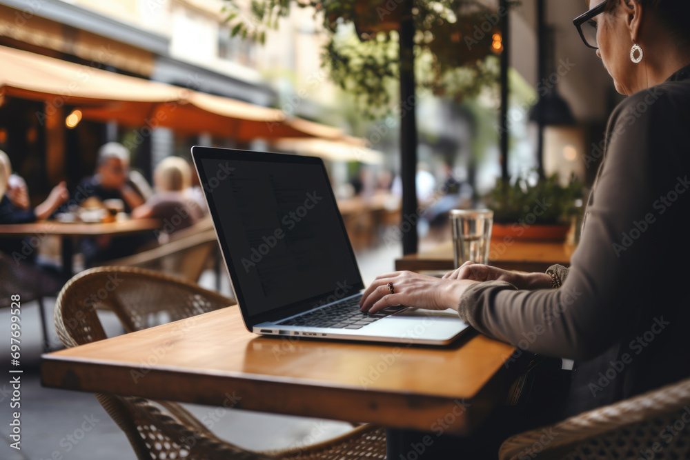 Woman working on laptop at cafe. Concept captures modern work flexibility. Woman working on laptop at cafe. Concept captures modern work flexibility.